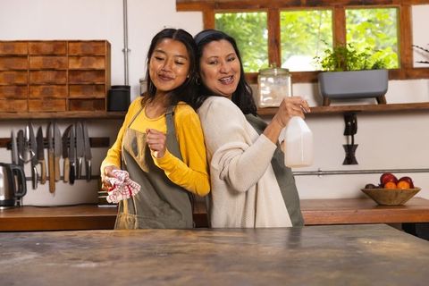 Mother and daughter bonding through kitchen cleaning