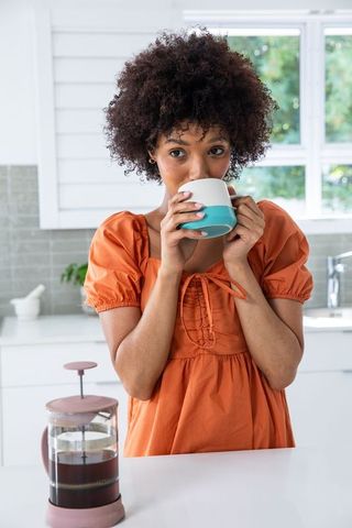 Woman Enjoying Coffee Morning at Modern Kitchen