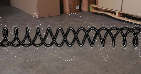 Long black coiled hose lying on concrete warehouse floor with dotted visualization overlay