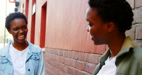 Joyful Twin Sisters Interacting in Urban Setting
