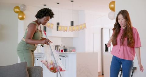 Lesbian couple cleaning after birthday celebration