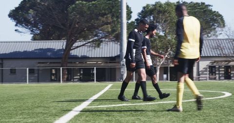 Soccer Players Strategizing on Clear Day in Outdoor Field