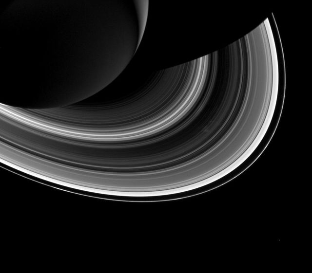 Among the interplay of Saturn shadow and rings, Mimas, which appears in the lower-right corner of the image, orbits Saturn as a set of the ever-intriguing spokes appear in the B ring to the right of center in this image from NASA Cassini spacecraft.