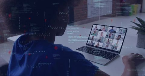 Developer monitoring code during remote video conference on laptop at home desk