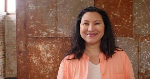 Confident woman in industrial studio with rustic background