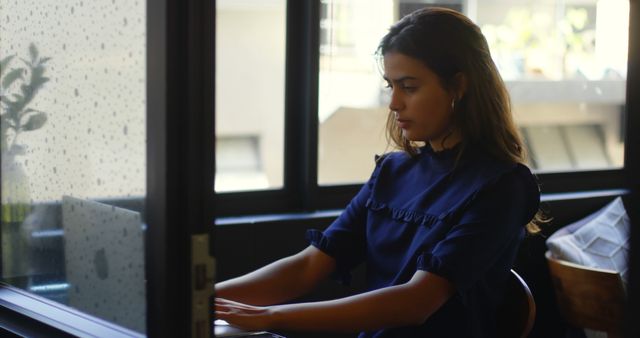 Woman Using Laptop at Desk by Window on Rainy Day - Download Free Stock Images Pikwizard.com