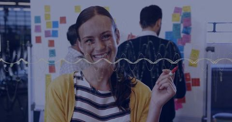 Smiling woman leading collaborative brainstorming at glass planning wall with colorful notes