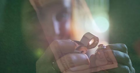 Female goldsmith checks ring amidst floating currency