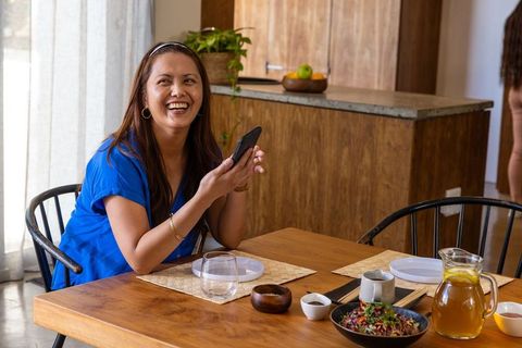 Joyful Woman Enjoying Leisure Time at Rustic Dining Table