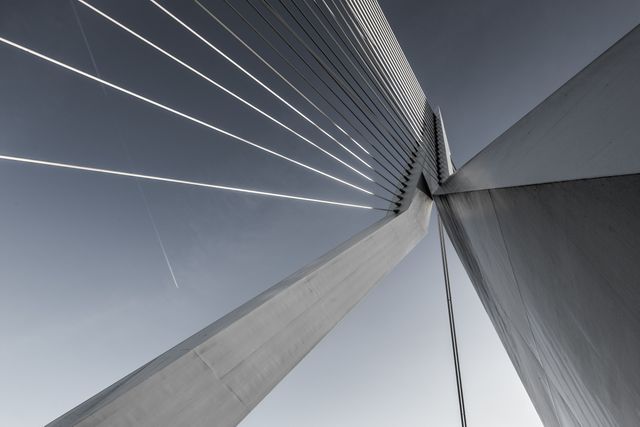 Sleek lines and geometric shapes of modern suspension bridge captured at an artistic angle, highlighting engineering marvel. Ideal for advertising municipal projects, infrastructure concepts, architectural showcases, or magazines and websites focusing on contemporary urban design.