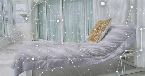 Modern daybed lounging in bright sunroom with quilted gray duvet and woven tan pillow