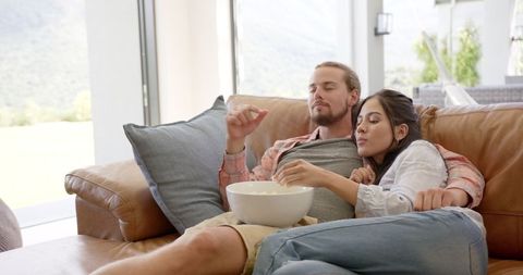 Relaxed Couple Enjoying Movie with Popcorn on Sofa - Download Free Stock Images Pikwizard.com
