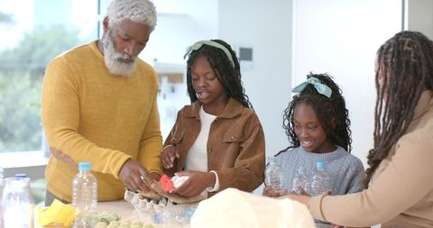 Multigenerational Family Decorating Eggs and Cooking Together in Bright Kitchen