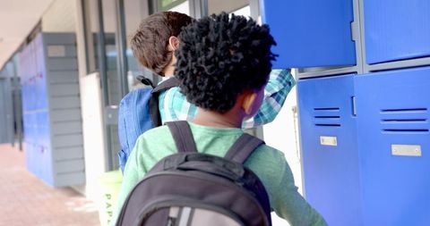 Children Placing Equipment in Locker Before Class