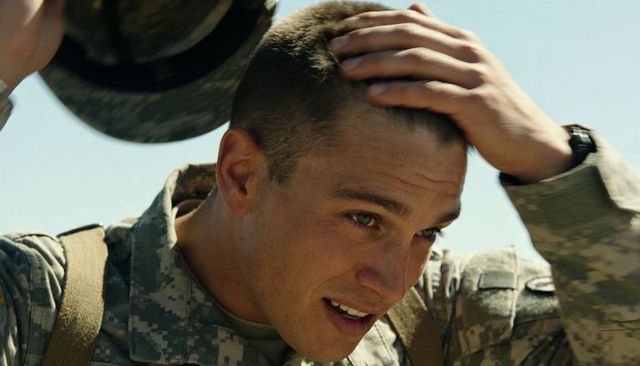 Young soldier adjusting camo helmet while touching buzzcut wearing digital camo uniform
