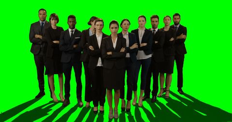 Professional Team Posing in Business Attire on Solid Green Background