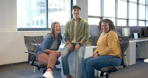 Smiling diverse team collaborating in bright modern open-plan office
