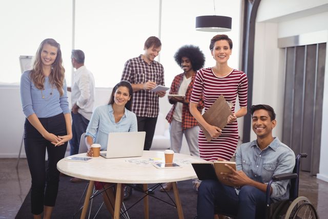 Portrait of smiling business team with handicap colleague in creative office