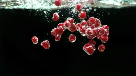 Fresh Raspberries Splashing into Crystal Clear Water