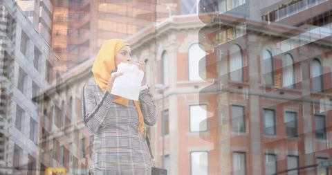 Young Woman with Hijab Eating in Vibrant Urban Setting