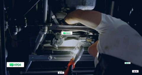 Technician inspecting machinery with digital interface icons