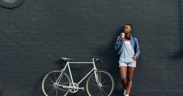 Young Woman Relaxing with Coffee by Brick Wall and Bike - Download Free Stock Images Pikwizard.com