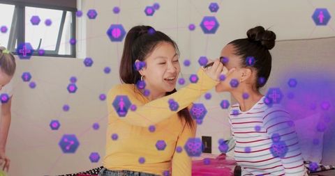 Teen friends applying makeup and laughing on bed with futuristic purple hexagon overlay