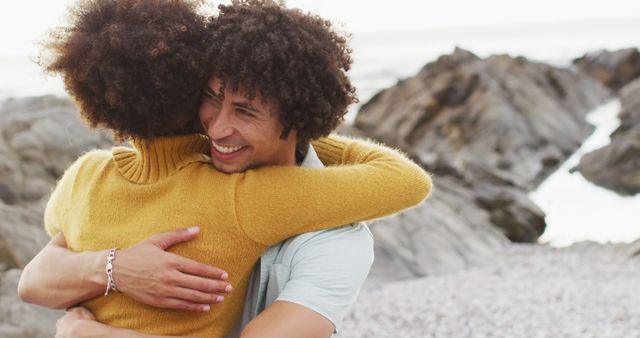 Happy couple hugging by the coastline, showcasing love and companionship. Ideal for promoting romantic destinations, relationship advice blogs, and advertisements focused on travel, fashion, and outdoor gear. Perfect for illustrating affectionate relationships, beach getaways, and nature appreciation.