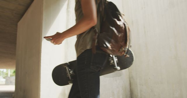 Teenager Holding Skateboard and Phone Outdoors - Download Free Stock Images Pikwizard.com