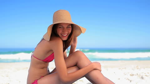 Joyful Woman in Straw Hat Relaxing on Sunny Beach Day