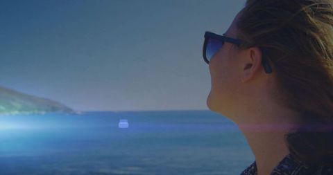 Woman Gazing at Serene Sea Horizon with Sunglasses