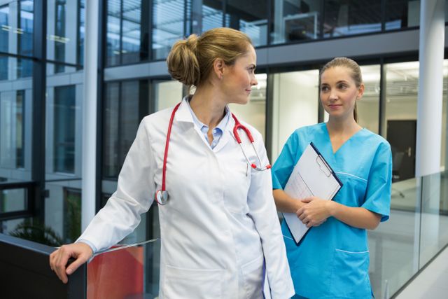 Female doctor and nurse standing in corridor at hospital