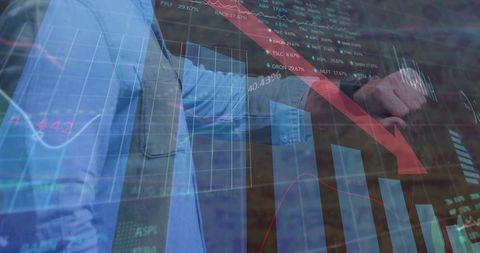 Business professionals analyzing falling market charts on glass display with red down arrow
