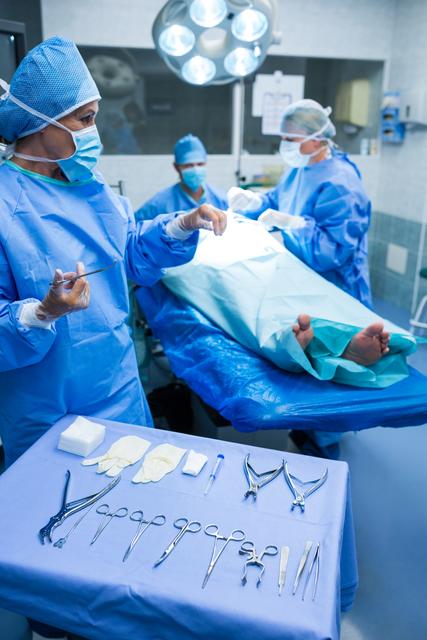Surgeon looking at scissor in operation room at hospital