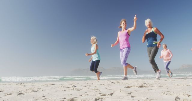 Senior women enjoying jogging on a sandy beach with blue skies in the background. This depicts a group of older women engaging in fitness and maintaining a healthy lifestyle through outdoor activities. Ideal for promoting senior fitness, health and wellness programs, active living, and outdoor exercise routines.