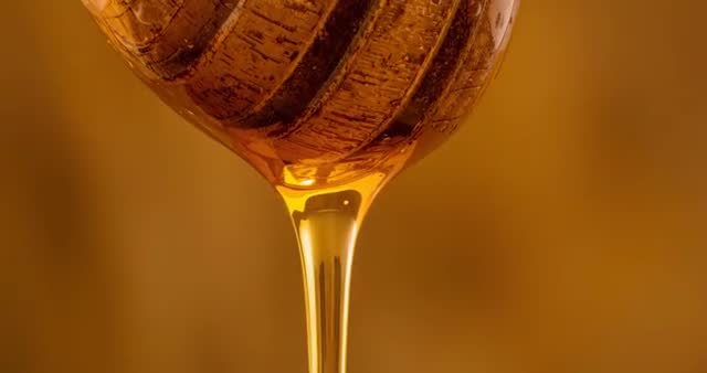 Rotating Honey Dipper Dripping Fresh Golden Honey