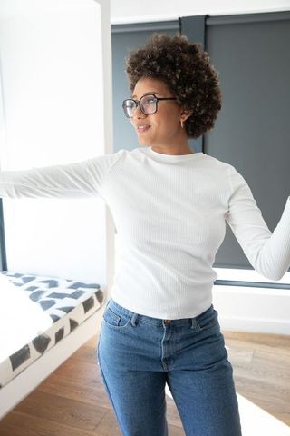 Modern Young Woman Enjoying Natural Light in Sunlit Room