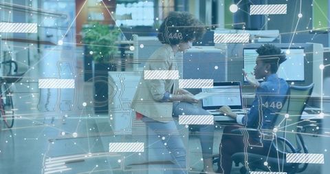 Colleagues Collaborating on Data Presentation in Modern Office