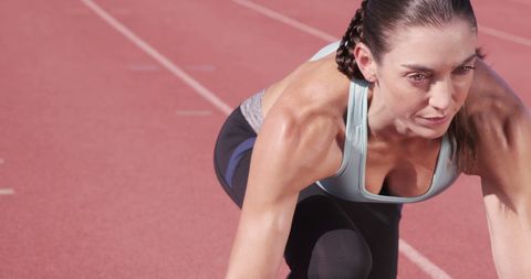 Focused Female Athlete Preparing for Race on Track - Download Free Stock Images Pikwizard.com
