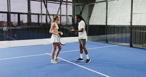 Diverse athletes enjoying padel tennis on modern blue court