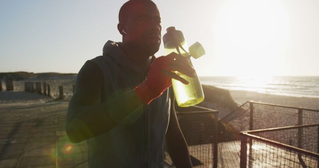 Fitness Enthusiast Taking Hydration Break During Beach Run at Sunset - Download Free Stock Images Pikwizard.com