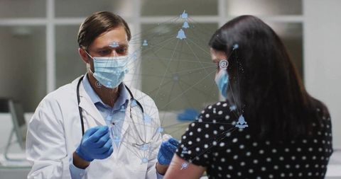 Masked doctor prepares syringe in modern medical clinic