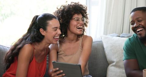 Friends Relaxing and Laughing on Comfortable Couch