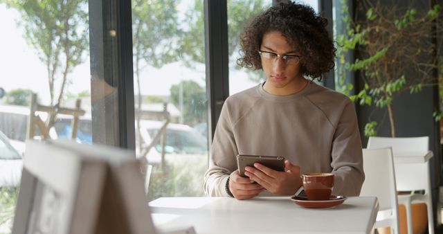 Young Man Browsing Tablet with Coffee at Cafe - Download Free Stock Images Pikwizard.com