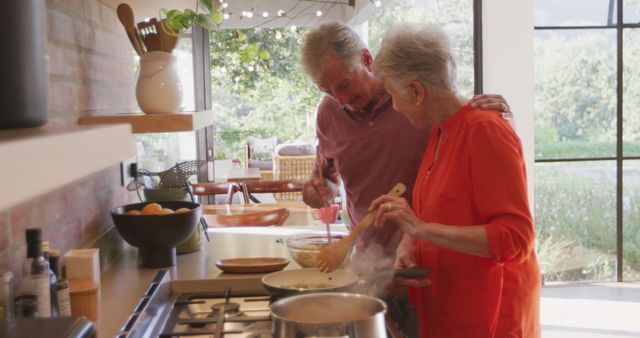 A cheerful senior couple is seen chopping vegetables and composting in a modern kitchen, capturing a moment of togetherness and healthy living. This can be used for advertisements about retirement communities, healthcare for seniors, or sustainable living tips. It can also be featured in articles on family bonding, modern kitchens, eco-friendly lifestyles, senior wellness, and recipes for older adults.
