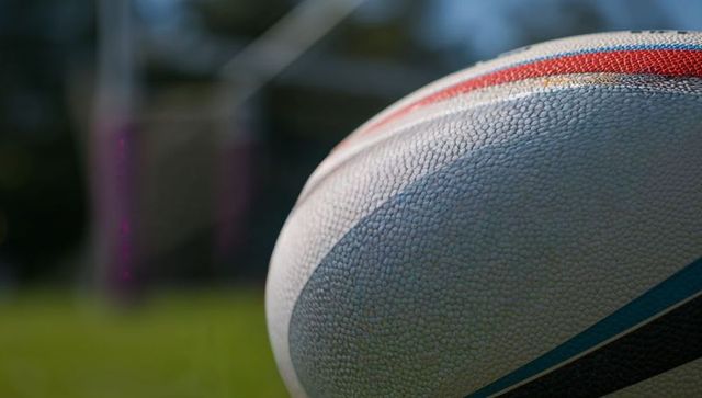 Textured Rugby Ball with American Football Goalposts in Background