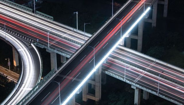 Nocturnal Elevated Highway Interchange Carrying Streaking Red and White Light Trails
