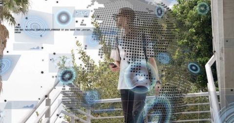 Young man descending campus stairs with backpack holding smartphone with ar hud overlays