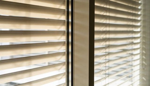 Daylight Filtering Through Venetian Blinds Casting Soft Shadows on Window Frame