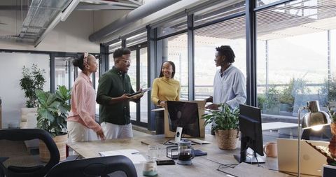 Diverse team collaborating enthusiastically in modern office environment